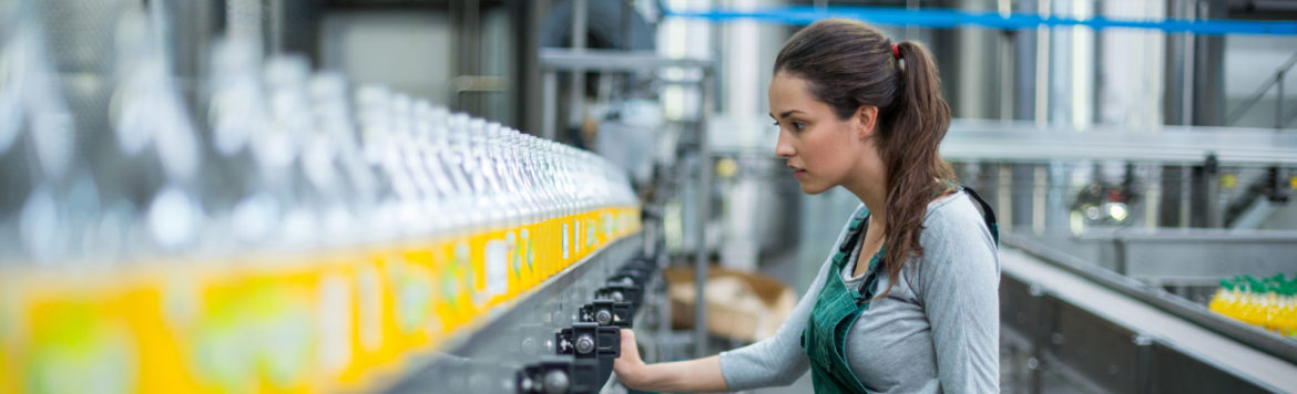Female factory worker standing near production line